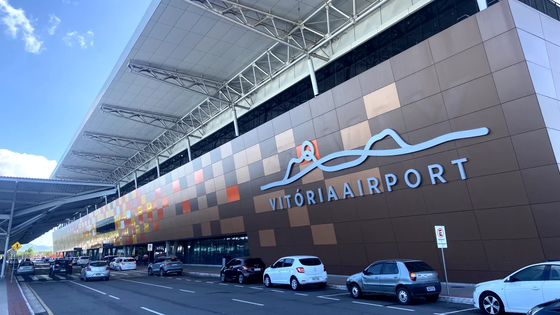 Fachada do Aeroporto de Vitória com veículos na área de embarque